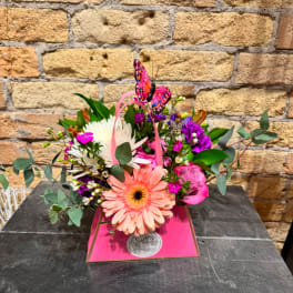 Pink and white mixed bouquet in a bright pink gift box with a butterfly topper