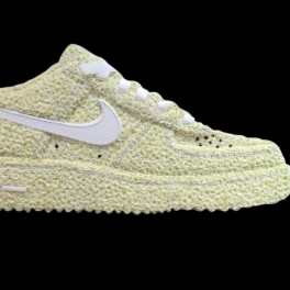 A pale yellow Nike sneaker covered in textured floral material