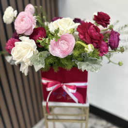 Pink and white roses in a red gift box with ribbon