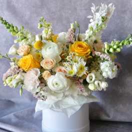 Bouquet of yellow, white, and blush flowers in a white hat box