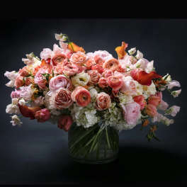 Large bouquet of pink and peach roses in a glass vase
