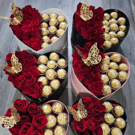 Heart-shaped boxes of red roses and gold-wrapped chocolates