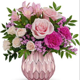 Pink roses and alstroemeria in a pink glass vase