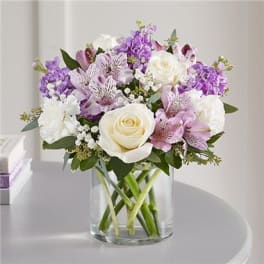 Bouquet of white and lavender flowers in a clear glass vase