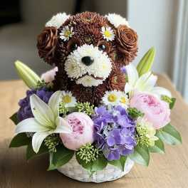 Flower basket with a teddy bear face made from blooms and lilies, plus pink and purple flowers