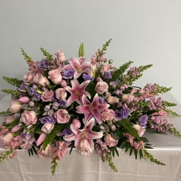 Low floral centerpiece with pink lilies, roses, and purple blooms