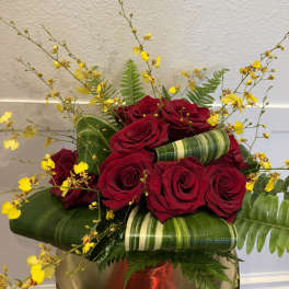 Red roses with yellow spray flowers in a vase