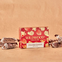 Box of Wildwood chocolate caramels with wrapped candies on a tan background