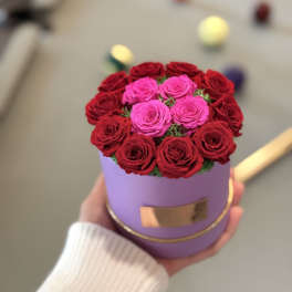 Pink and red roses arranged in a lavender round box