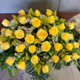 Yellow roses arranged with white filler flowers and greenery