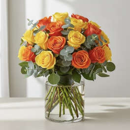 Bouquet of yellow and orange roses in a clear glass vase