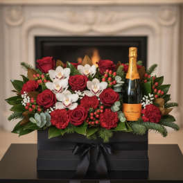 Red roses and white orchids arranged with a champagne bottle in a black gift box