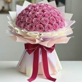 Bouquet of pink roses wrapped in pale paper with a red ribbon