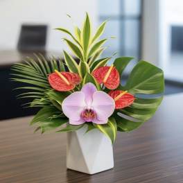 Tropical arrangement with a pink orchid and red anthuriums in a white vase