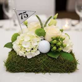 White floral centerpiece with a golf ball and table number flag