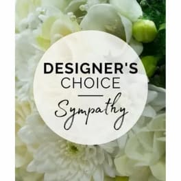 White floral sympathy arrangement with a designer's choice sign