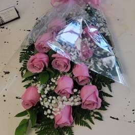 Pink rose bouquet wrapped in clear plastic with a pink bow