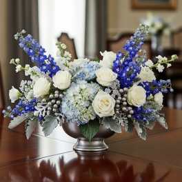 Blue and white floral centerpiece in a silver bowl vase
