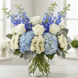 Blue and white floral arrangement in a clear glass vase