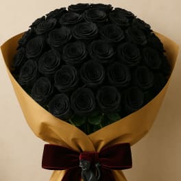 Bouquet of black roses wrapped in gold paper with a burgundy ribbon