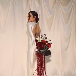 Bride in a white gown holding a red and white bouquet