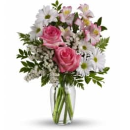 Pink roses and white daisies in a clear glass vase