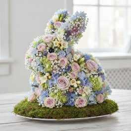 Floral bunny sculpture made of pastel roses and hydrangeas on a moss base