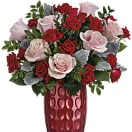 Red and pale pink roses arranged in a tall red vase