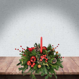 Christmas centerpiece with red candle, pinecones, and red ornaments