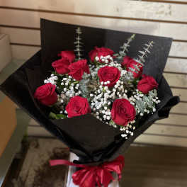 Bouquet of red roses with baby's breath in black wrap and a red ribbon