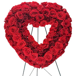 Heart-shaped wreath of red roses on a metal stand
