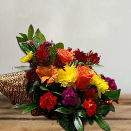 Colorful mixed flower bouquet in a woven cone holder