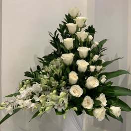 Tall white rose arrangement with orchids in a white vase
