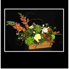 Mixed floral arrangement in a wooden box with orange, green, and white blooms