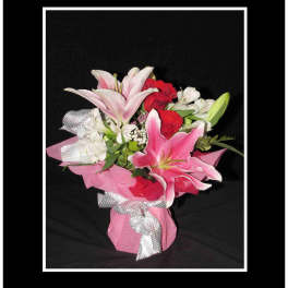 Bouquet of pink lilies and red roses wrapped in pink paper