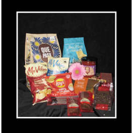 Assorted snack and candy gift basket with a pink flower accent