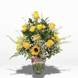 Yellow roses and a sunflower in a glass vase