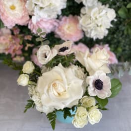 Cream roses and pale anemones in a blue vase