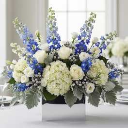 White and blue floral arrangement in a square box