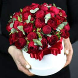 Red rose bouquet in a white hatbox with a red ribbon