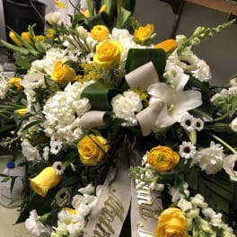 Large white and yellow funeral wreath with ribbon