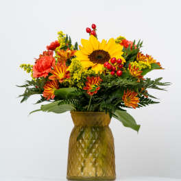 Sunflower and autumn flower arrangement in a gold vase