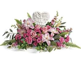 Pink lilies and roses arranged around a memorial heart plaque