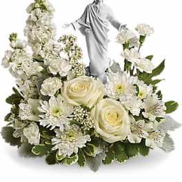 White floral arrangement with a small religious statue in the center
