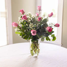 Pink roses arranged in a clear glass vase