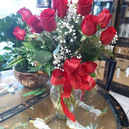 Bouquet of red roses with baby's breath in a glass vase