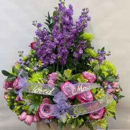 Purple and pink floral arrangement with ribbon labels for family members