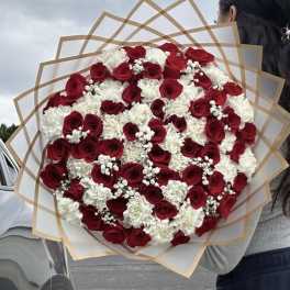 Large bouquet of red roses and white carnations wrapped in tan paper