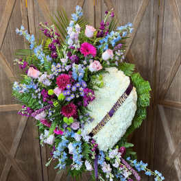 Heart-shaped funeral wreath with white flowers and pastel blooms