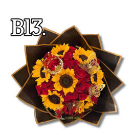 Bouquet of red roses and yellow sunflowers in dark wrapping with butterfly accents
